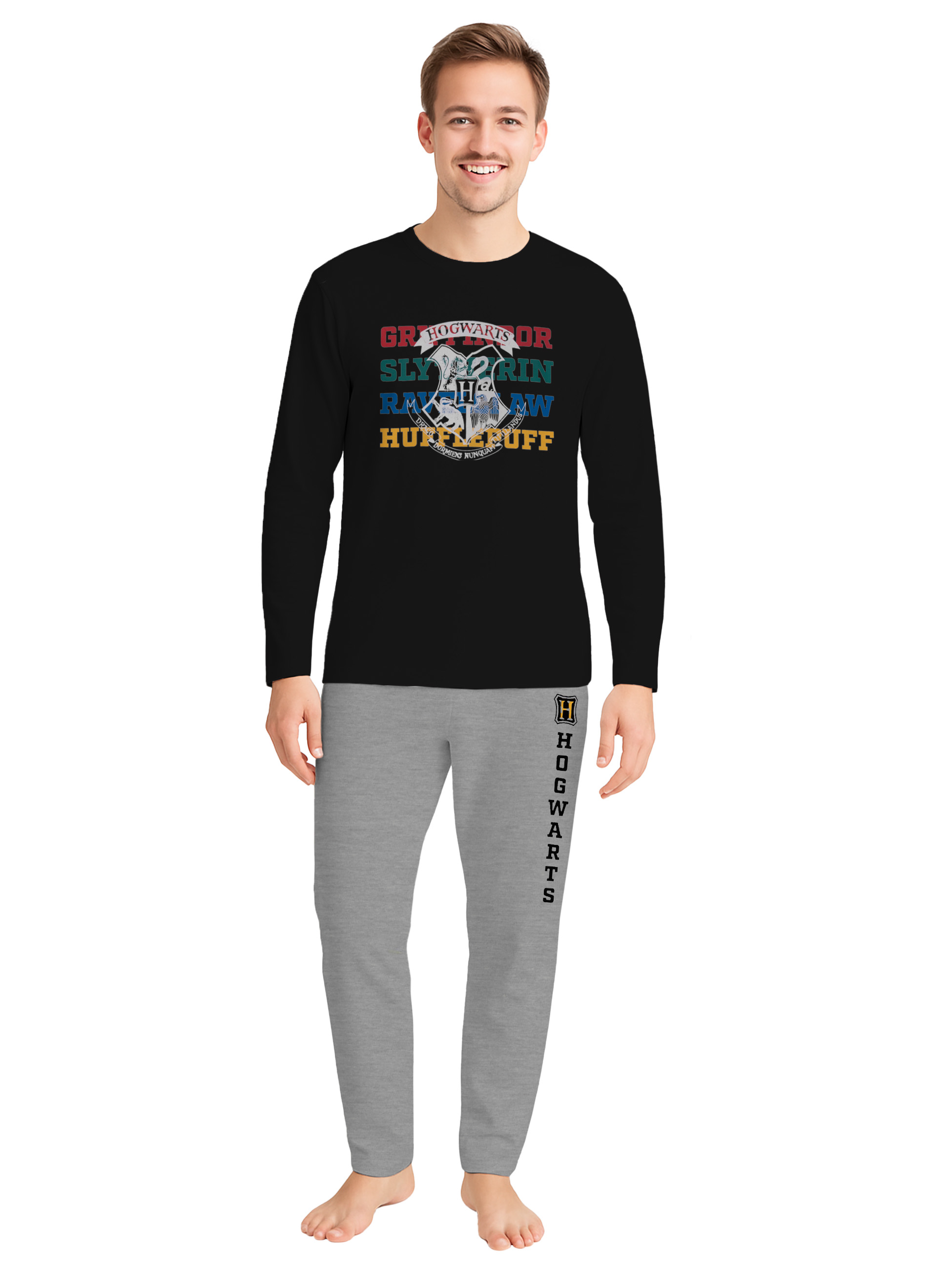 Ein Mann trägt ein schwarzes Hogwarts-T-Shirt mit Wappen und graue Jogginghosen.