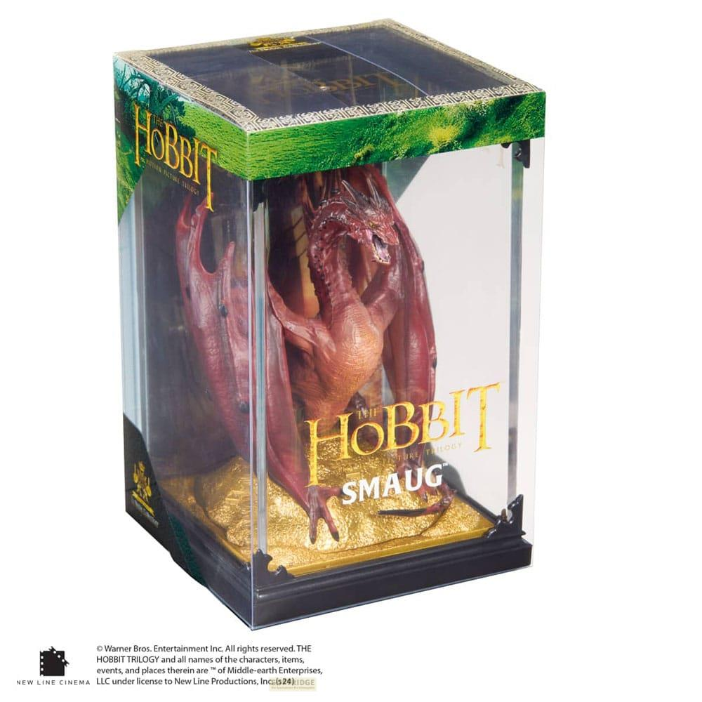 Eine rote Smaug-Drachenfigur aus Der Hobbit in einer Vitrine mit Goldbasis.