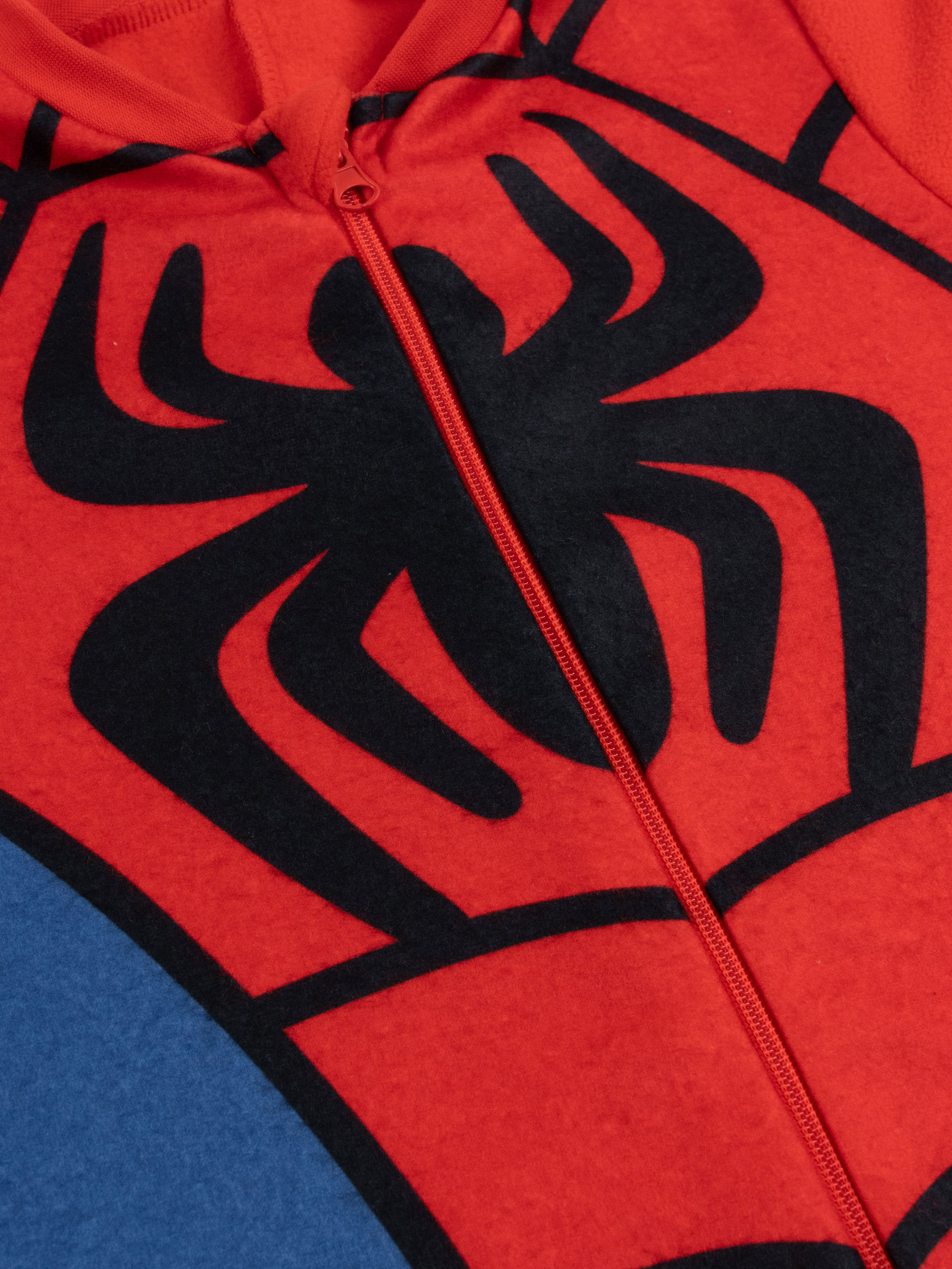 Roter Anzug mit schwarzem Spinnenmuster und rotem Reißverschluss.