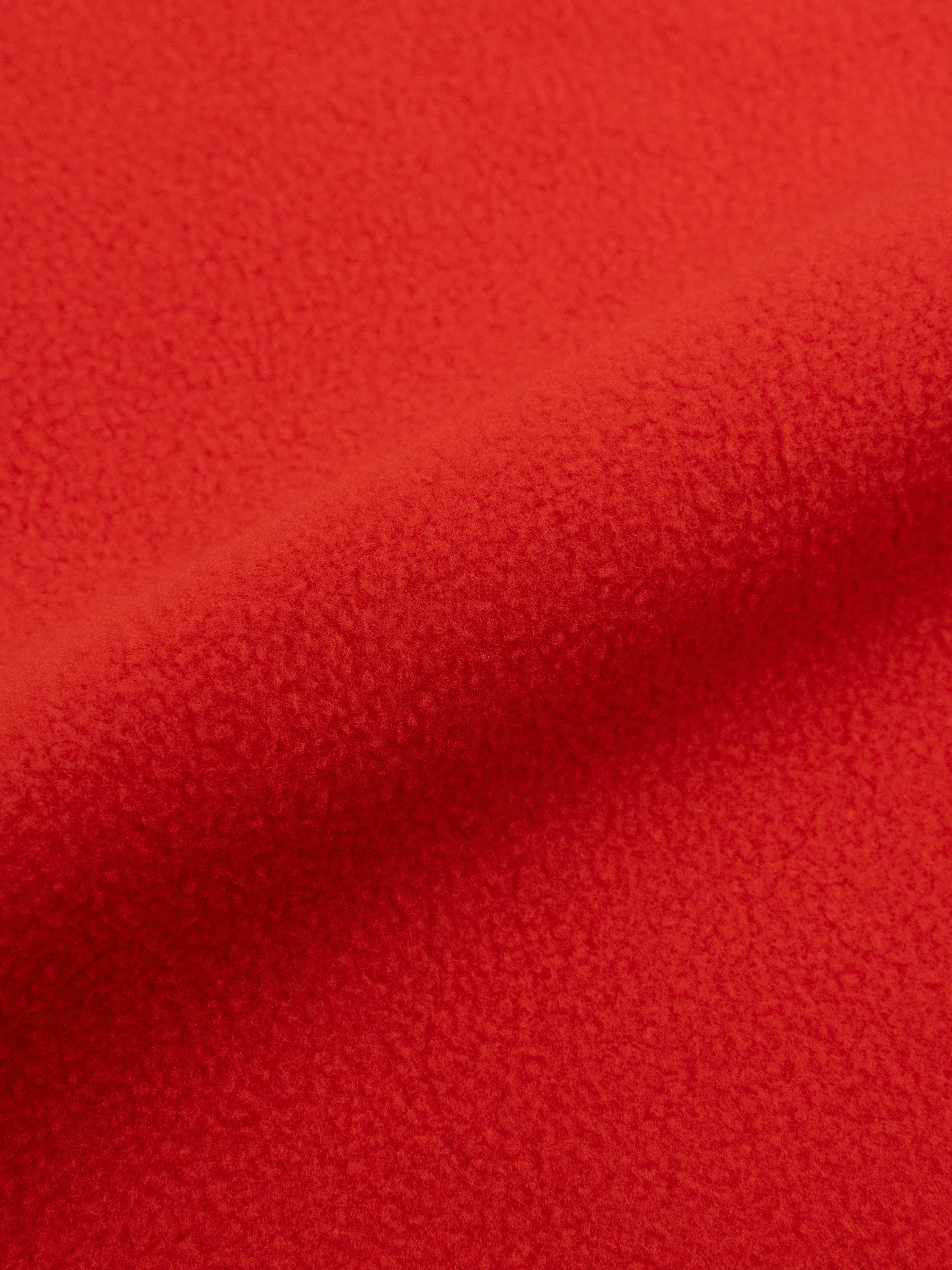 Nahaufnahme von rotem Fleece-Stoff mit Falten und Textur.