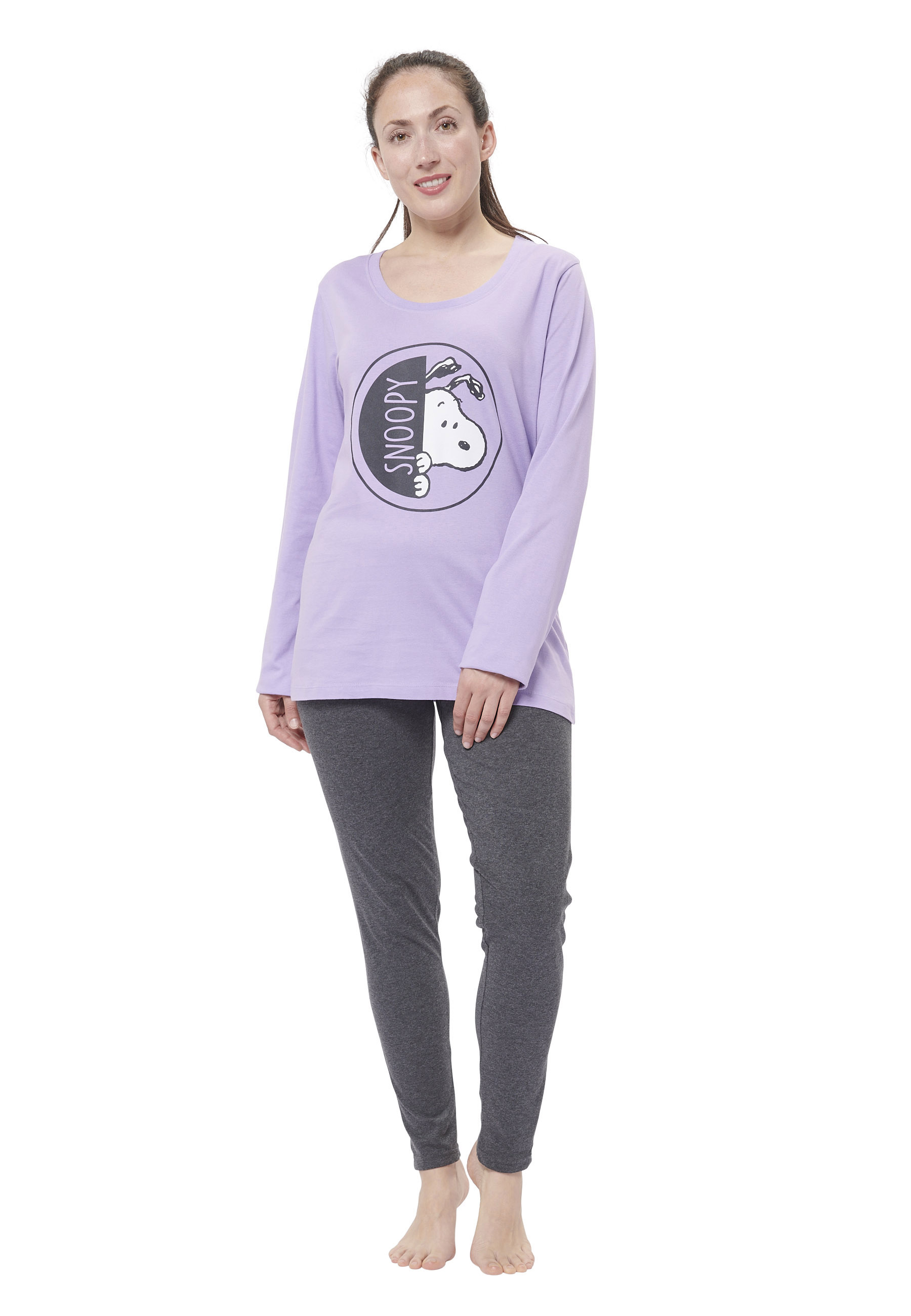 Eine Frau trägt ein lavendelfarbenes Snoopy-T-Shirt und graue Hosen.