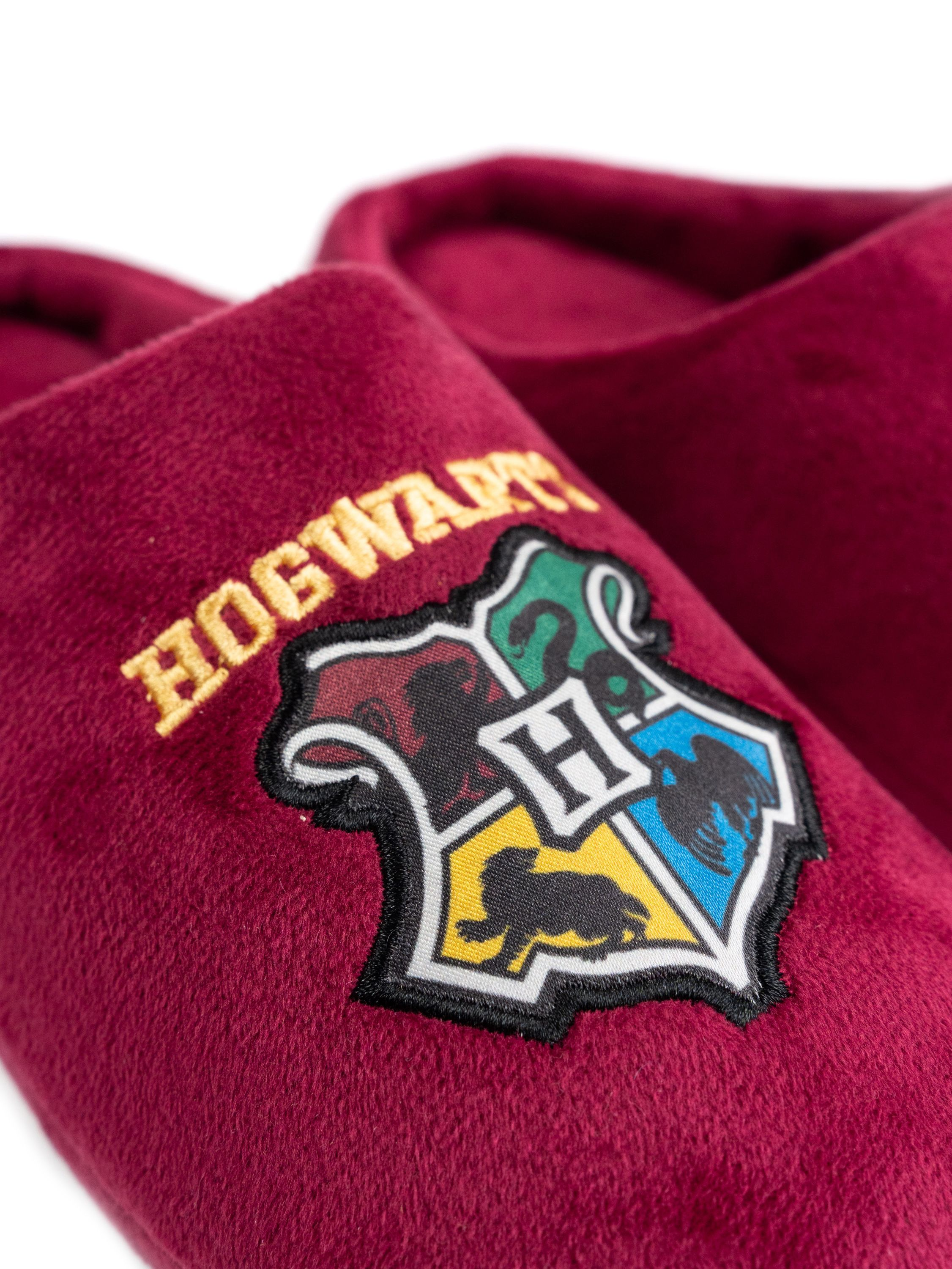 Bordeauxrote Hausschuhe mit Hogwarts-Wappen und „HOGWARTS“-Schriftzug.