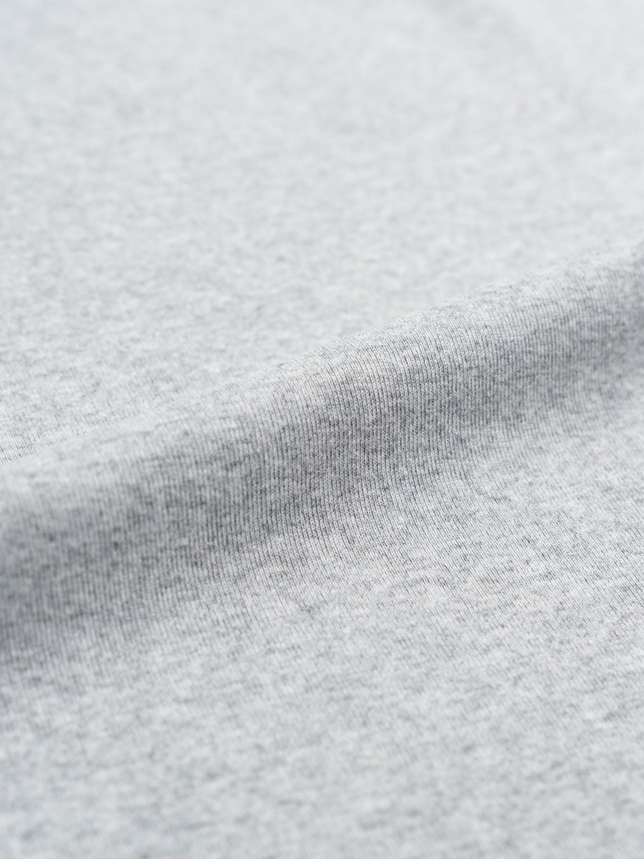 Grauer Stoff mit sichtbarer Textur und Falten.