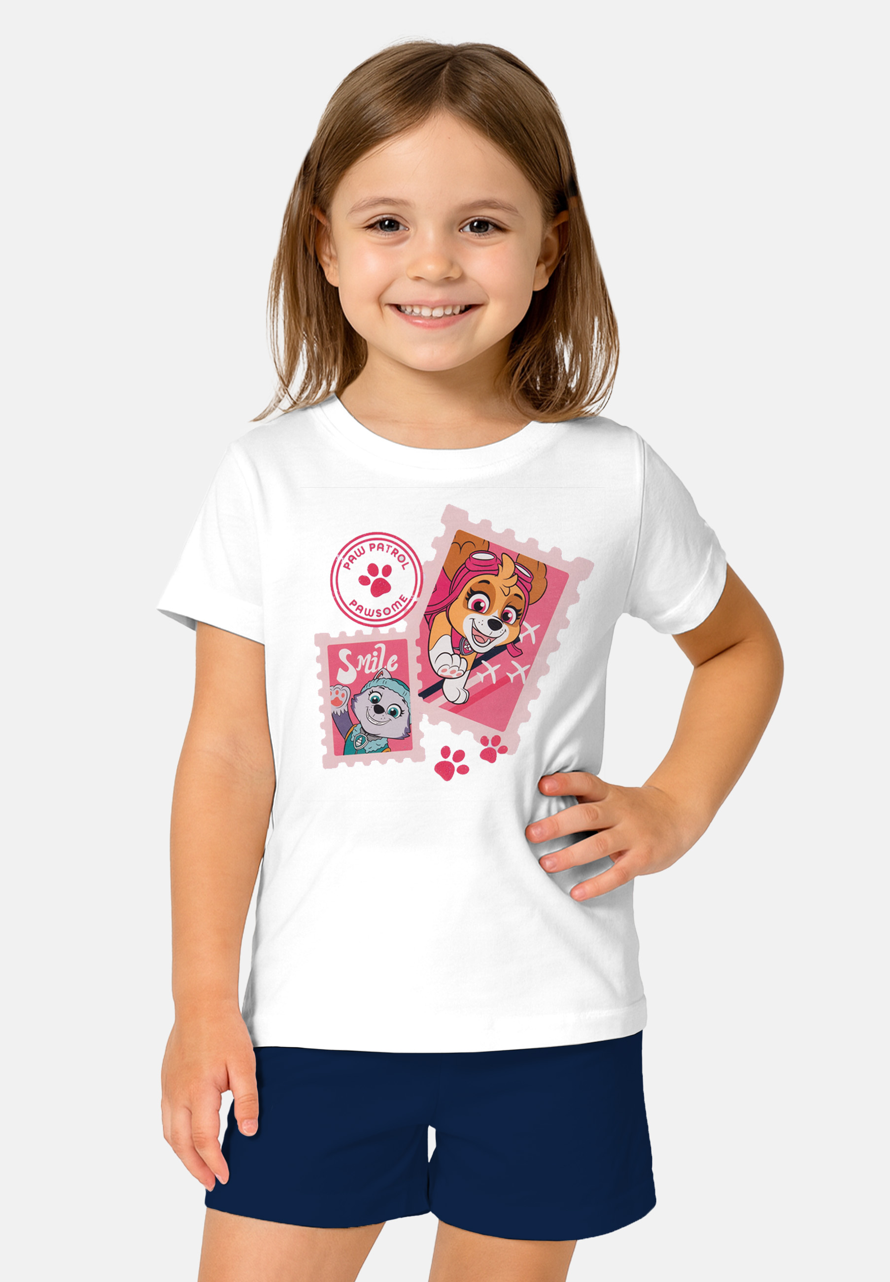Mädchen in weißem T-Shirt mit Paw Patrol-Aufdruck, lächelnd.