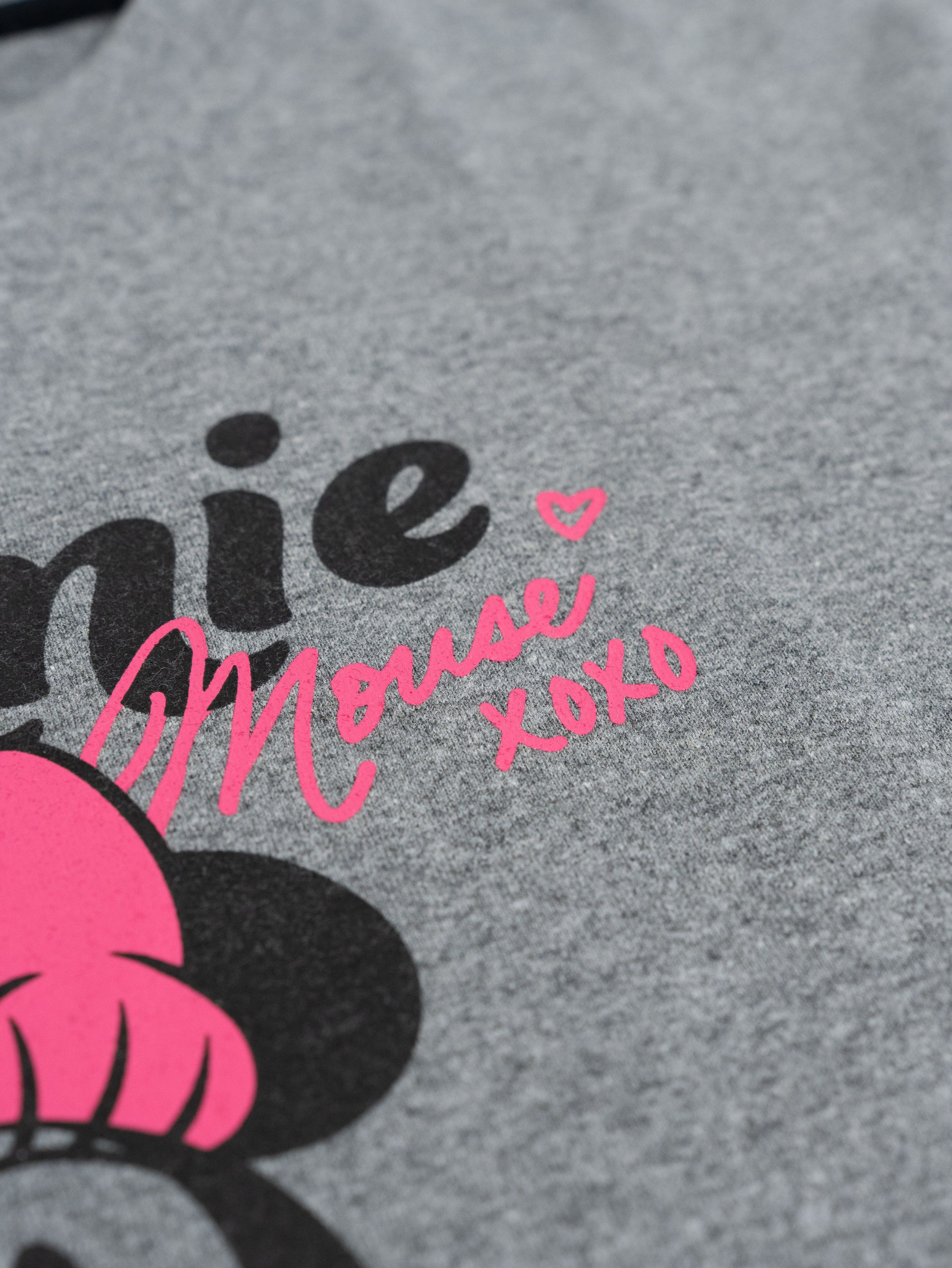 Graues T-Shirt mit schwarzer und pinker Minnie Maus Grafik.