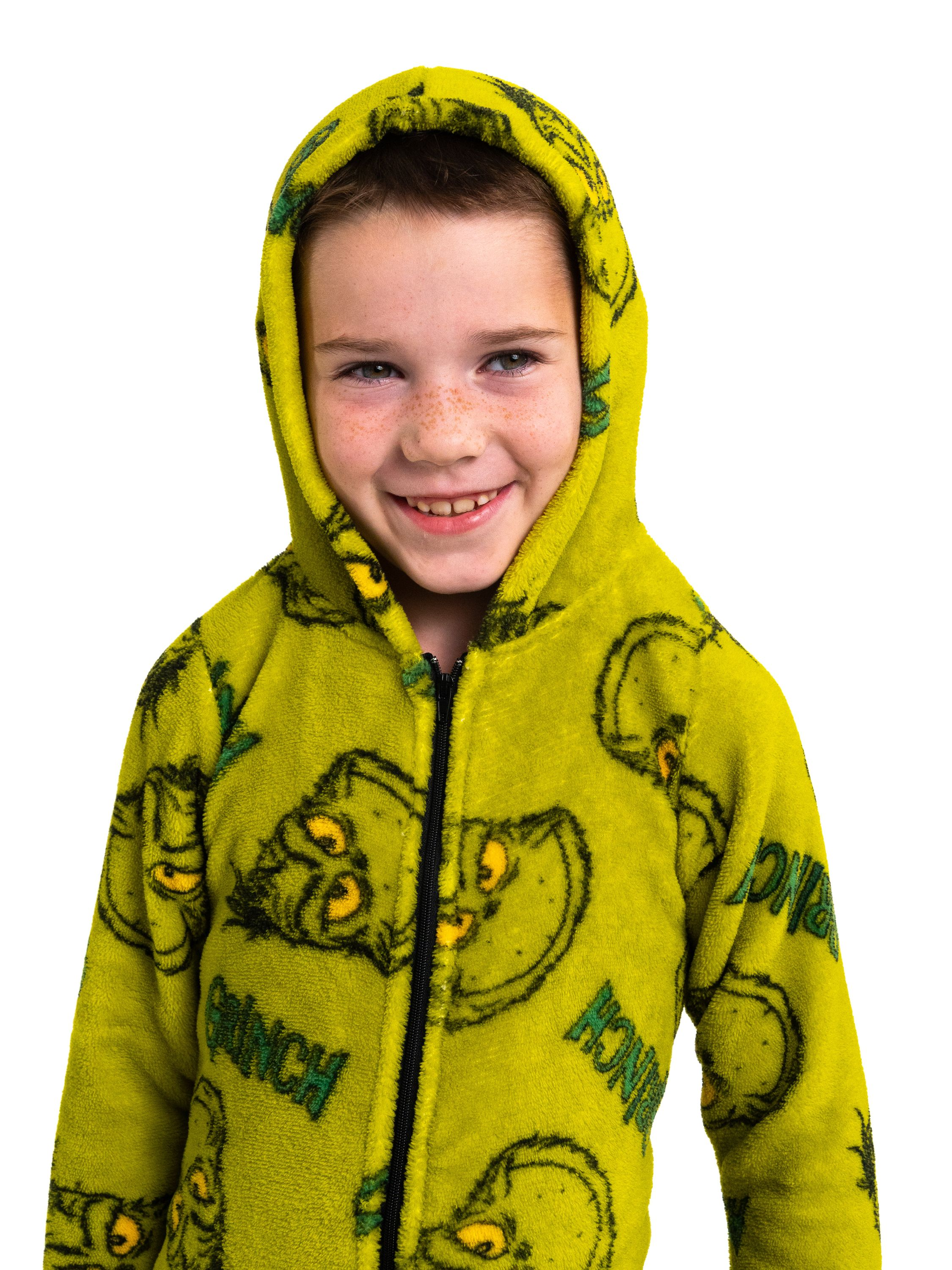 Ein lächelndes Kind in einem gelben Grinch-Pyjama mit Kapuze.