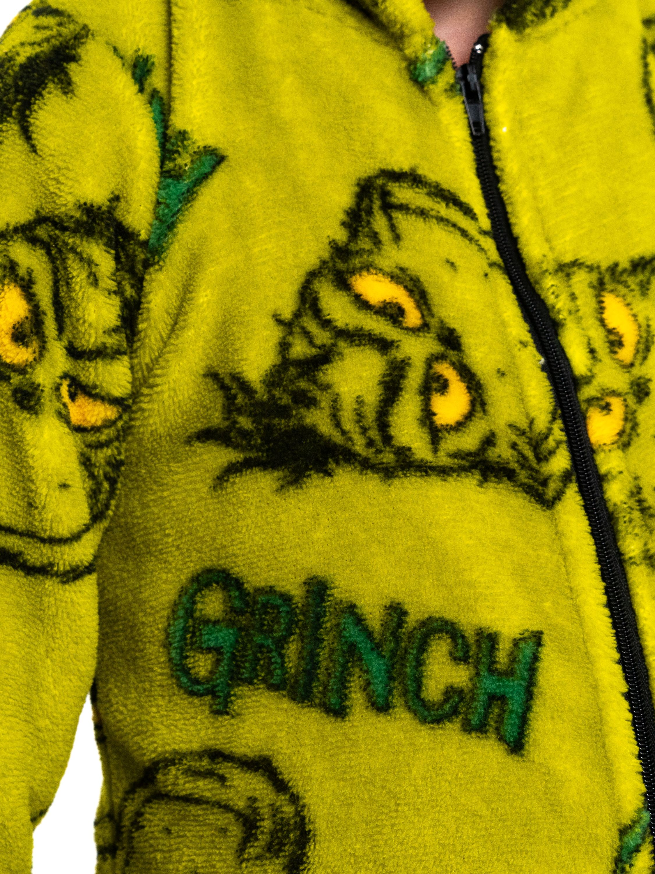 Ein gelber Fleece-Overall mit dem Grinch-Gesicht und dem Wort GRINCH.