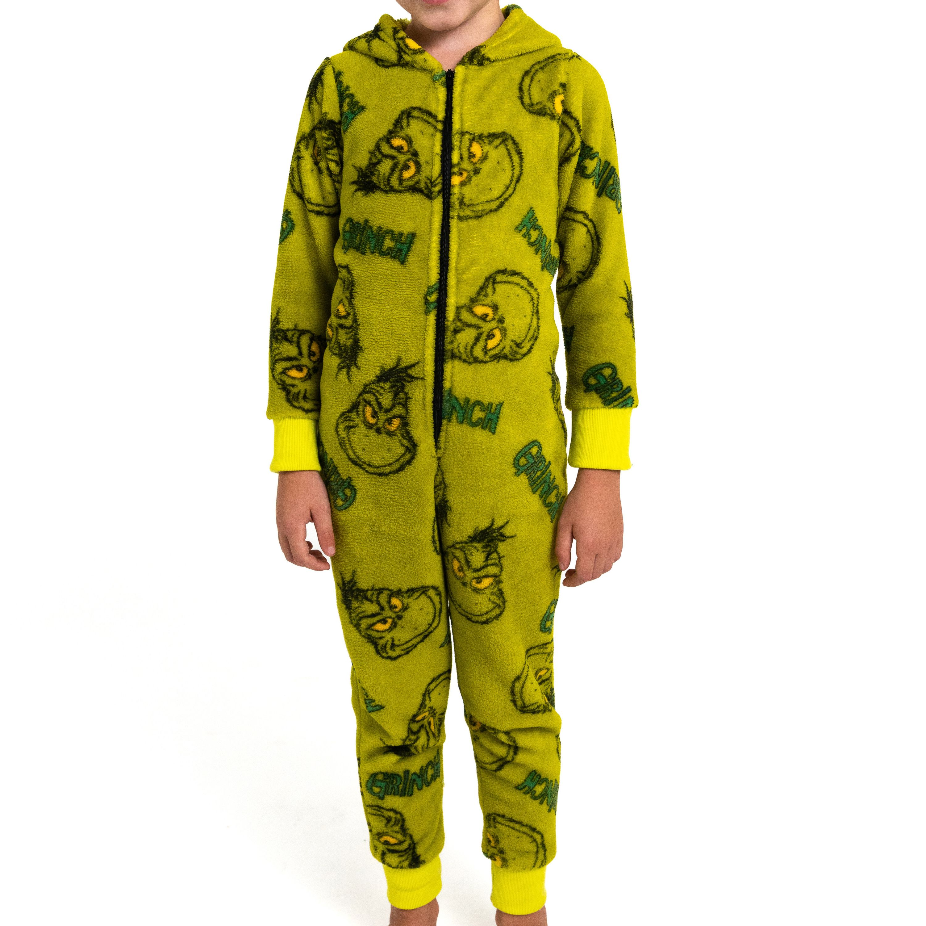 Ein Kind trägt einen grüngemusterten Onesie mit dem Grinch und gelben Bündchen.