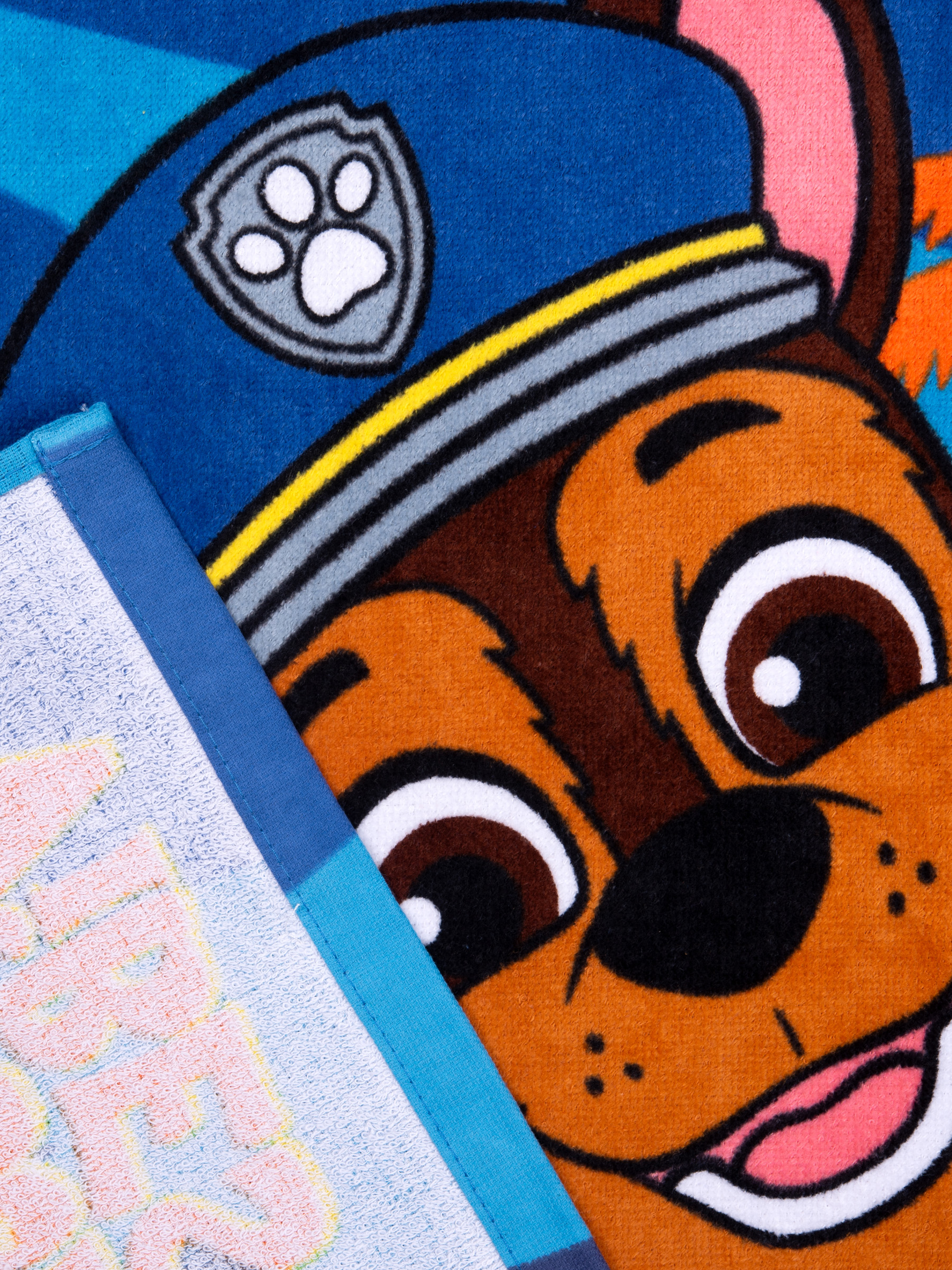 Ein Handtuch mit dem Gesicht von Chase aus Paw Patrol, blauem Kragen und Pfotenabdruck-Abzeichen.