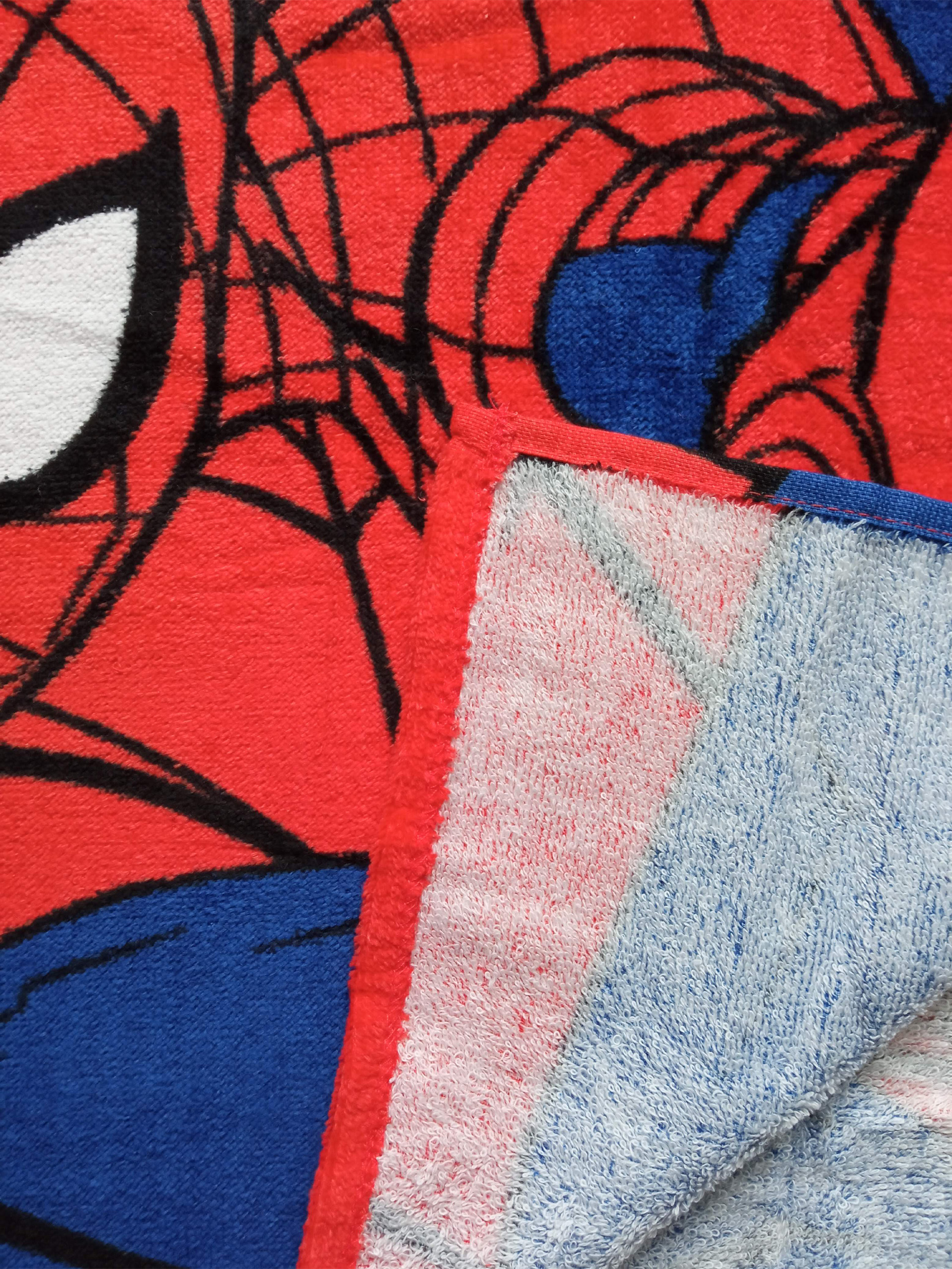 Detailaufnahme eines roten Handtuchs mit Spiderman-Motiv und blauen Akzenten.