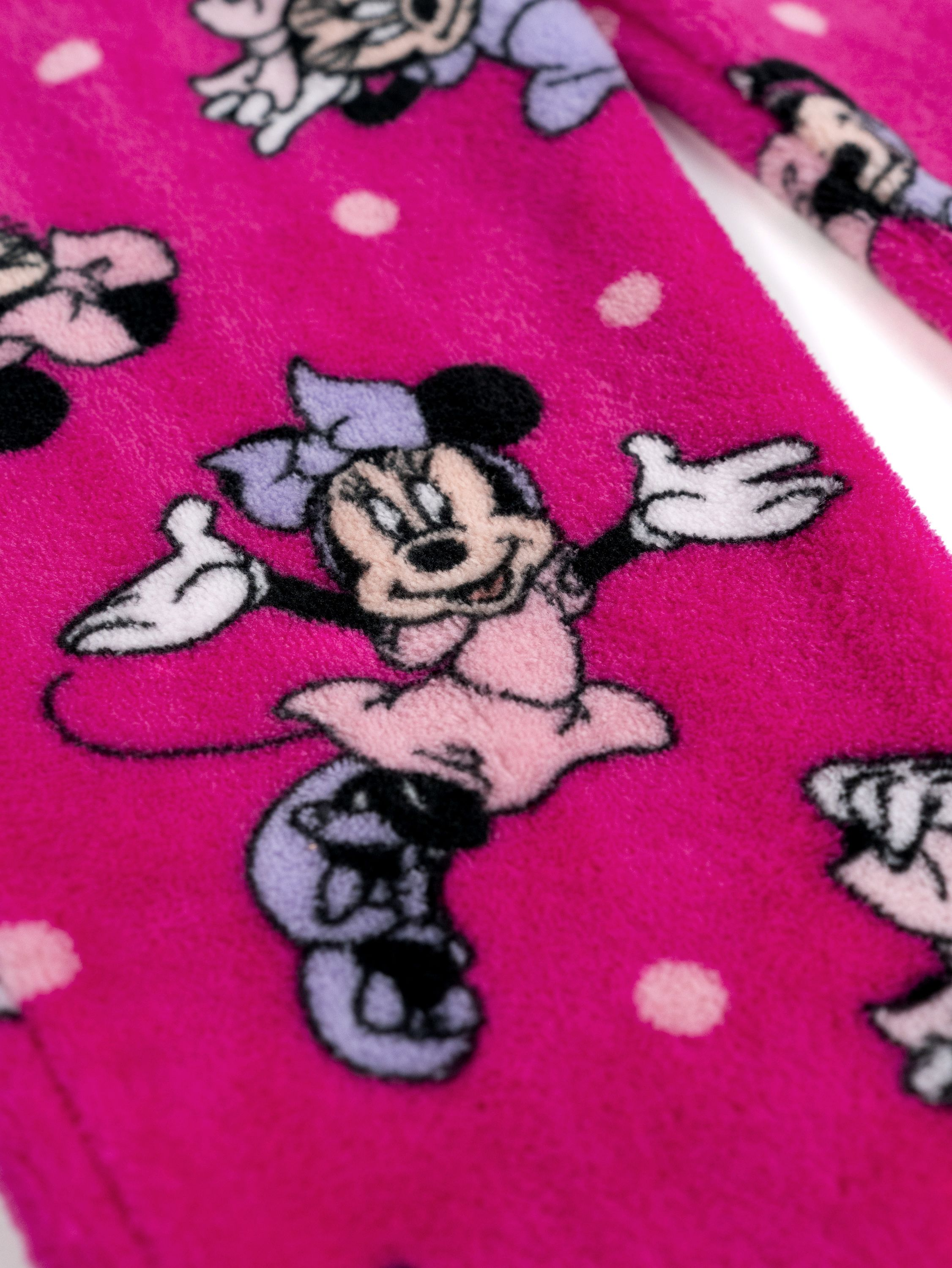 Ein rosa Stoff mit Micky-Maus-Motiven und weißen Punkten.