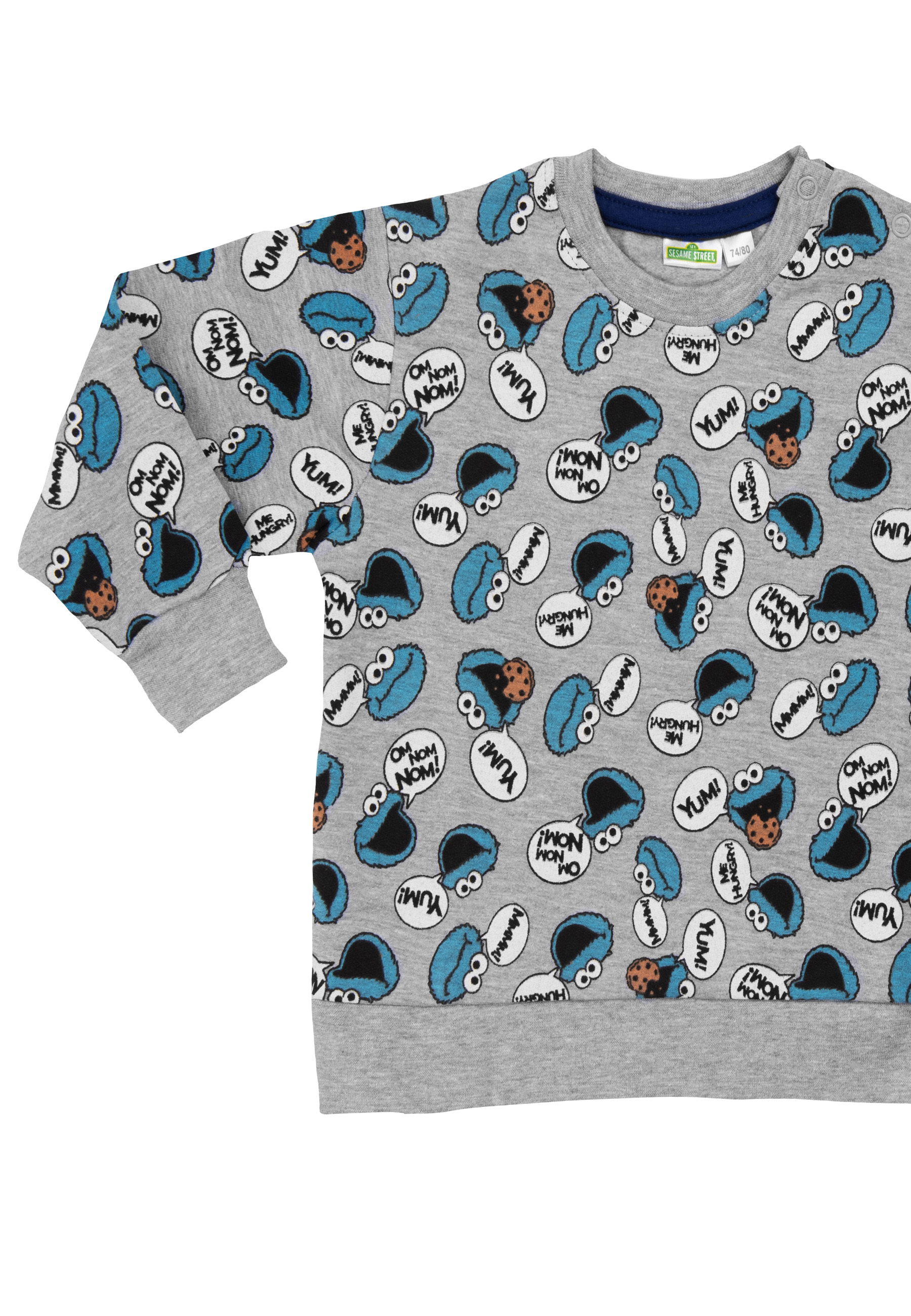 Grauer Pullover mit Cookie Monster Aufdruck und Sprechblasen mit 'YUM!'.