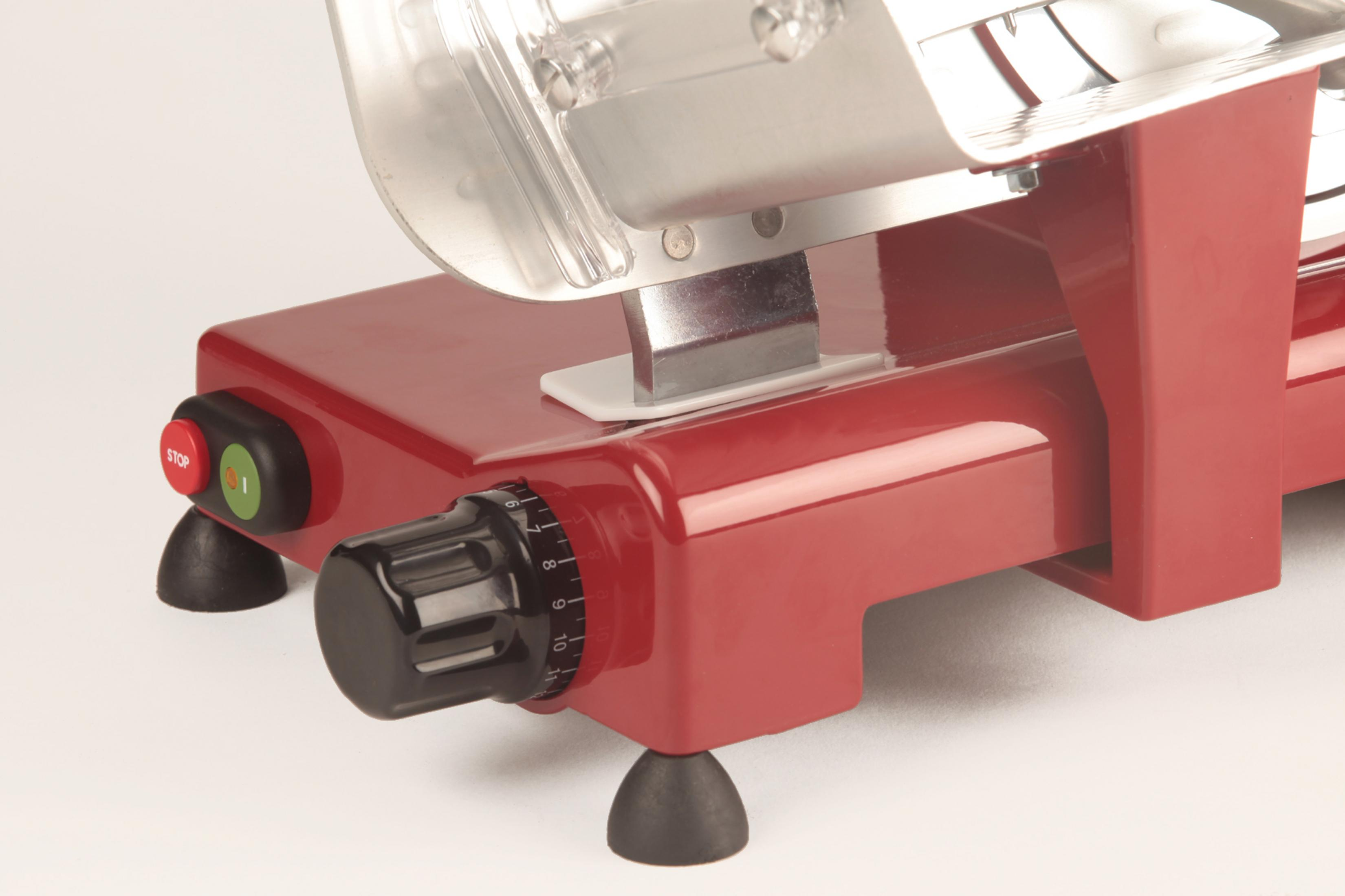 Une trancheuse à viande rouge avec lame argentée et boutons noirs.