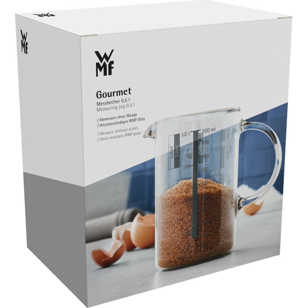 WMF Messbecher 0,5l gefüllt mit braunem Zucker, neben zerbrochenen Eiern.