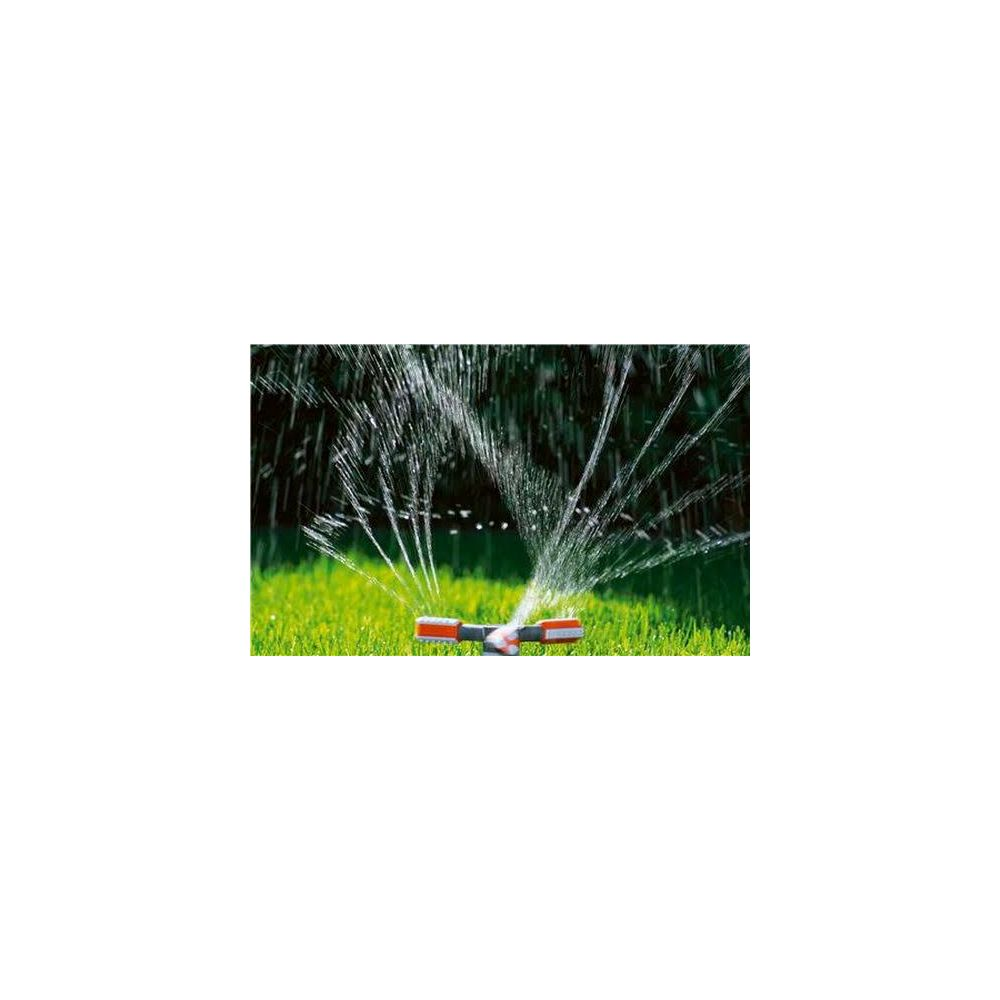 Ein Sprinkler bewässert einen grünen Rasen mit feinen Wasserstrahlen.