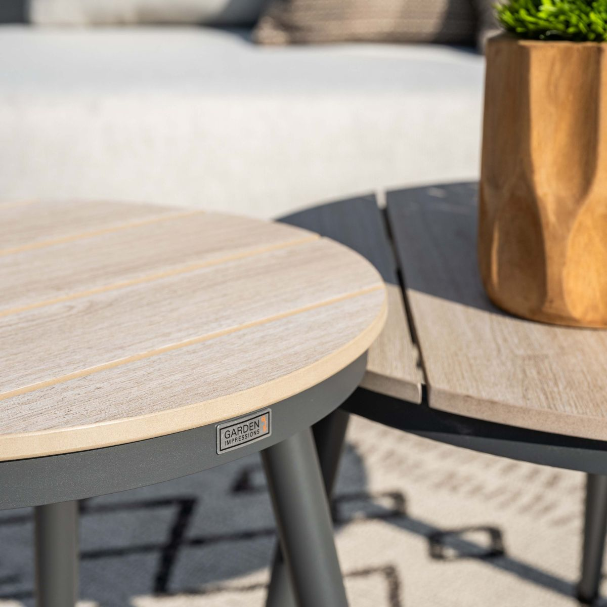 Twee buitentafels met houtlook en plantenbak. Grijs frame, licht houten blad.