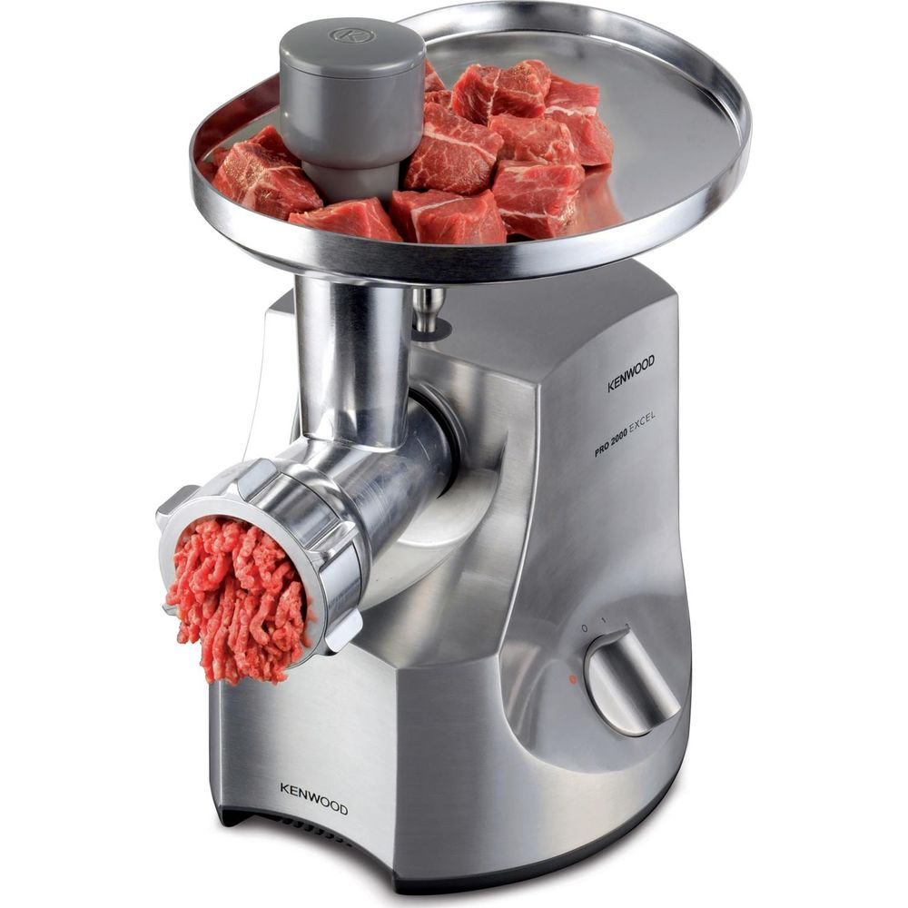 Maszynka do mielenia mięsa Kenwood z kawałkami mięsa na tacy i wychodzącym mięsem mielonym.