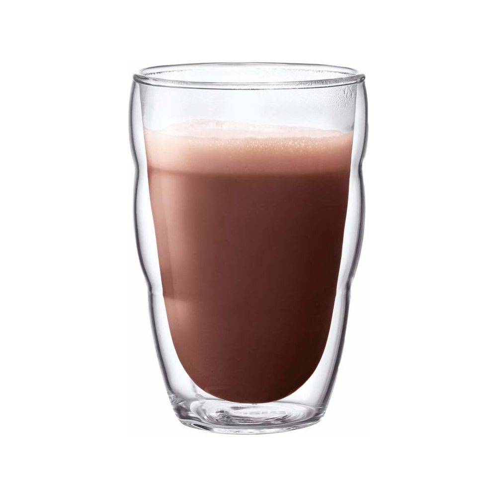 Doppelwandiges Glas gefüllt mit braunem Getränk und Schaum.