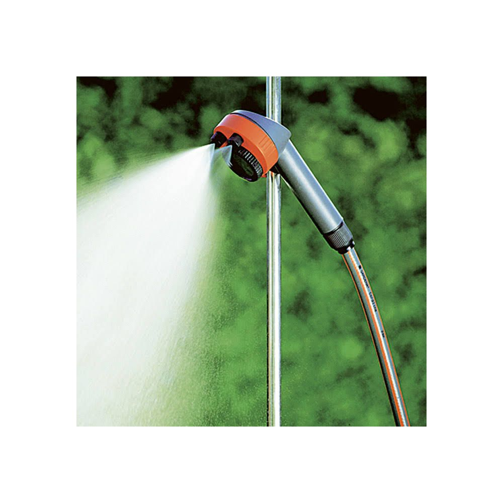 Wąż ogrodowy zrasza wodę, z pomarańczowo-szarym uchwytem.