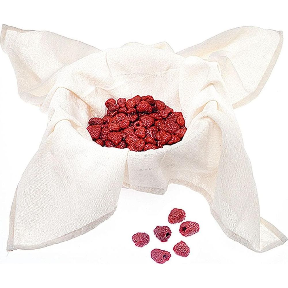 Getrocknete Himbeeren in einem weißen Stofftuch mit einigen Beeren daneben.