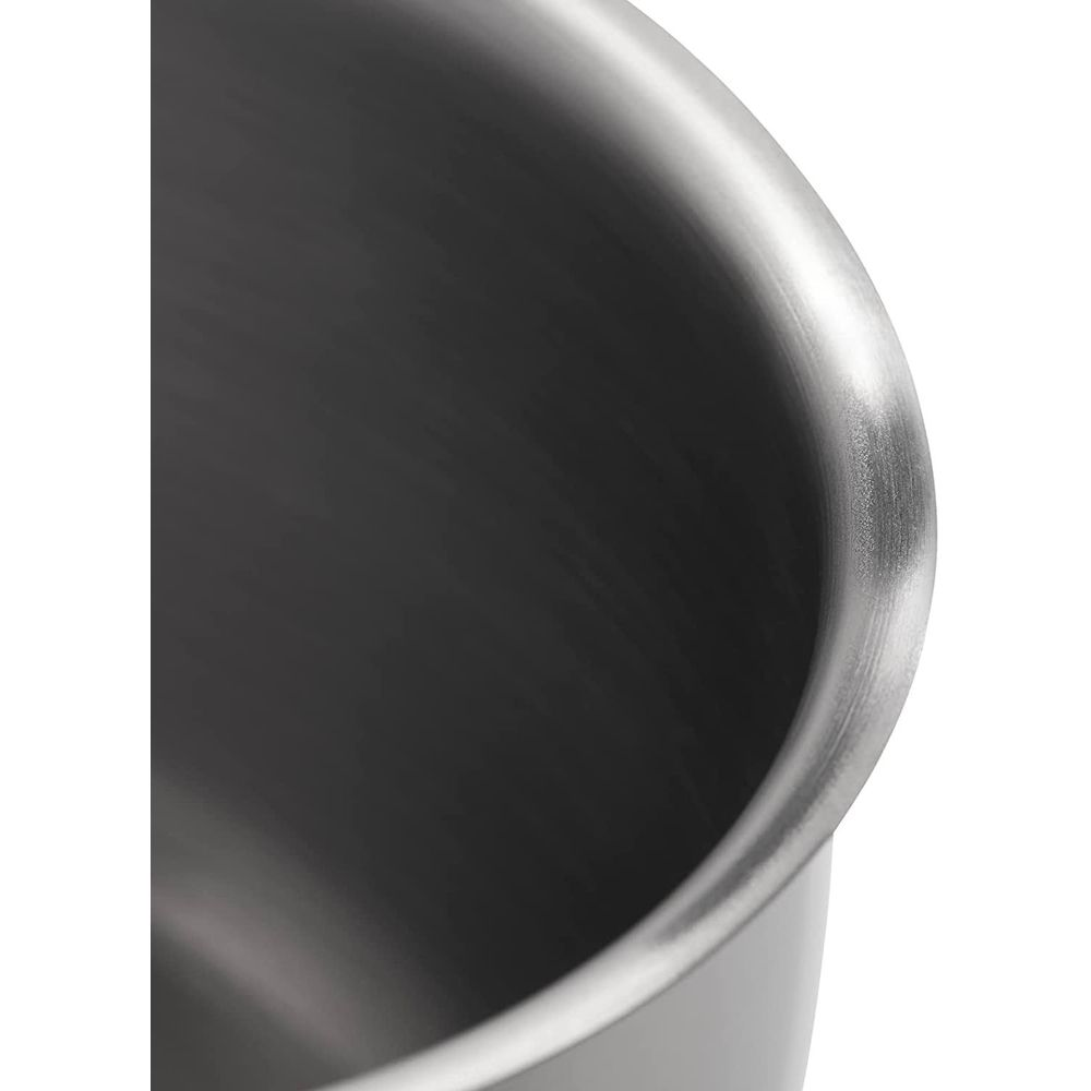 Zbliżenie metalowej strony garnka z polerowaną krawędzią.