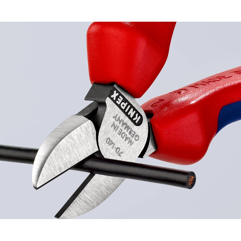 Rote Zangen schneiden ein schwarzes Kabel mit Kupferdraht.