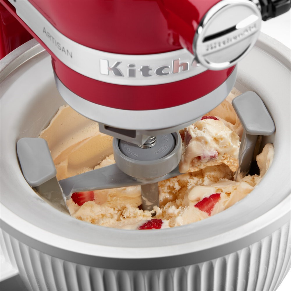 Ein roter KitchenAid-Eisbereiter mit Rührschüssel und cremigem Eis mit Erdbeeren.