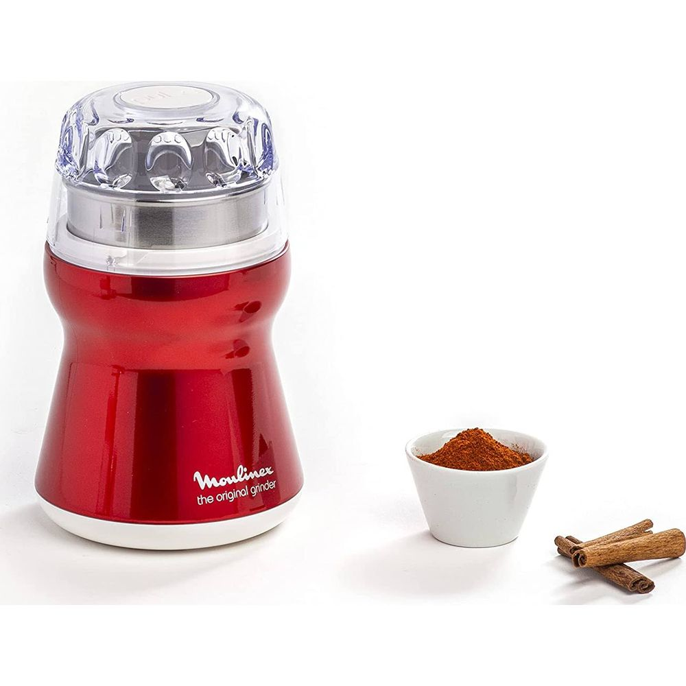 Ein roter Gewürz- und Kaffeemixer neben Zimtstangen und einer Schüssel mit Pulver.