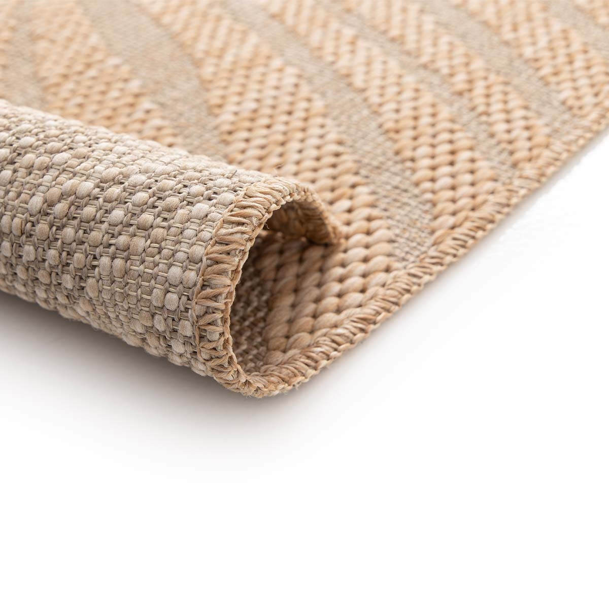 Een beige geweven vloerkleed, aan één kant opgerold tegen een witte achtergrond.