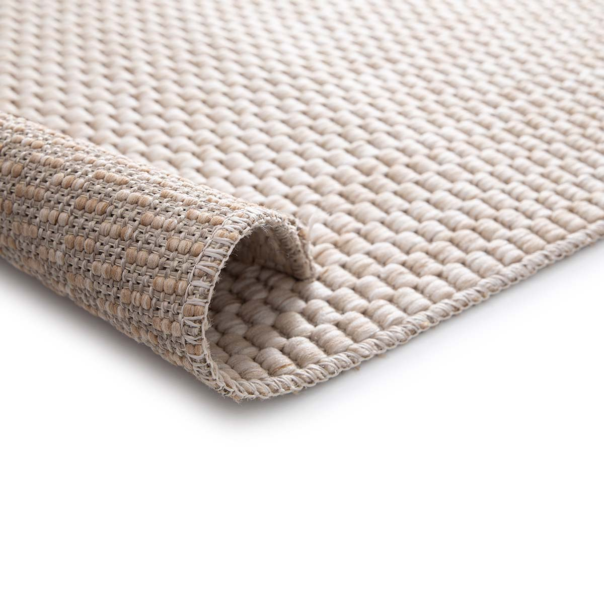 Een beige kleed is opgerold, de getextureerde weving is zichtbaar.