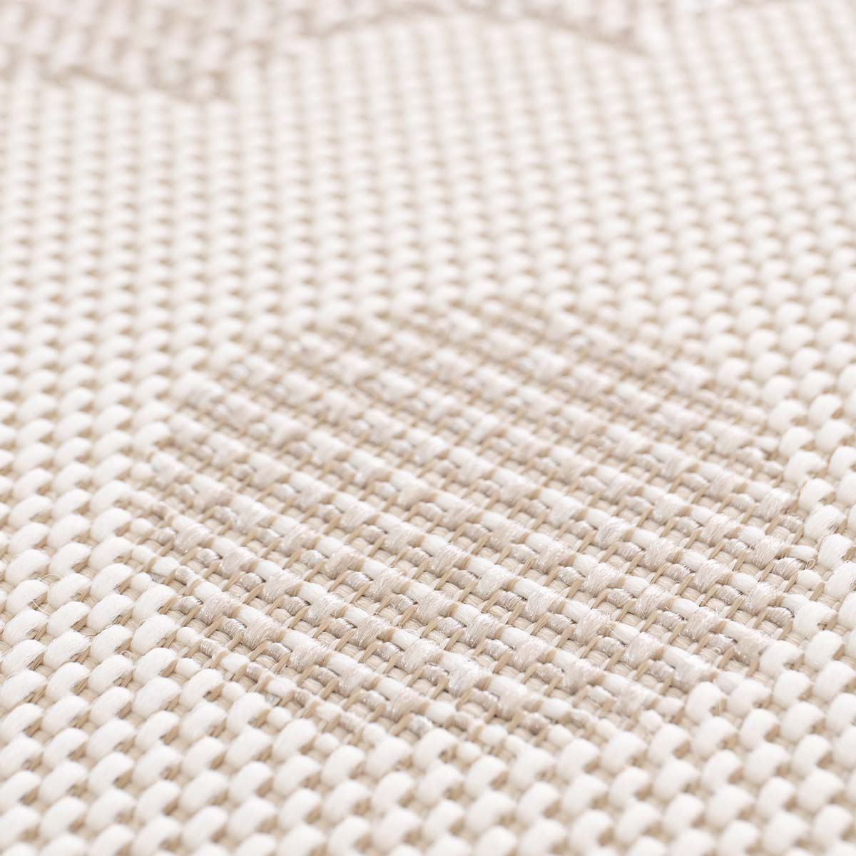 Close-up van beige textiel met geweven patroon en diagonale lijn.