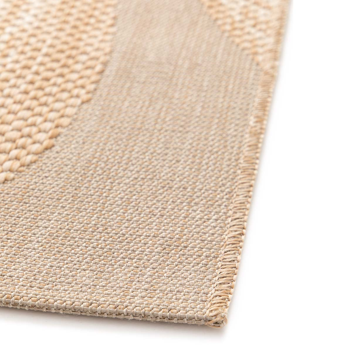Een beige vloerkleed met geometrisch patroon, close-up.