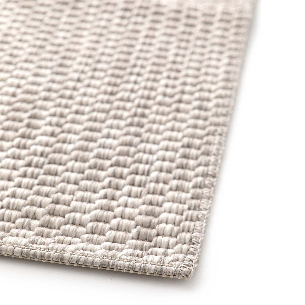 Een beige vloerkleed met een geweven patroon op een witte achtergrond.