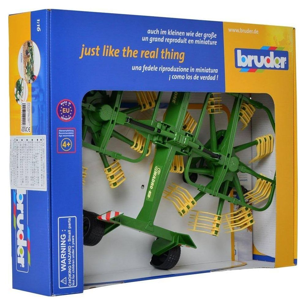 Zielona zabawka Bruder grabie do siana w pudełku, z żółtymi zębami.