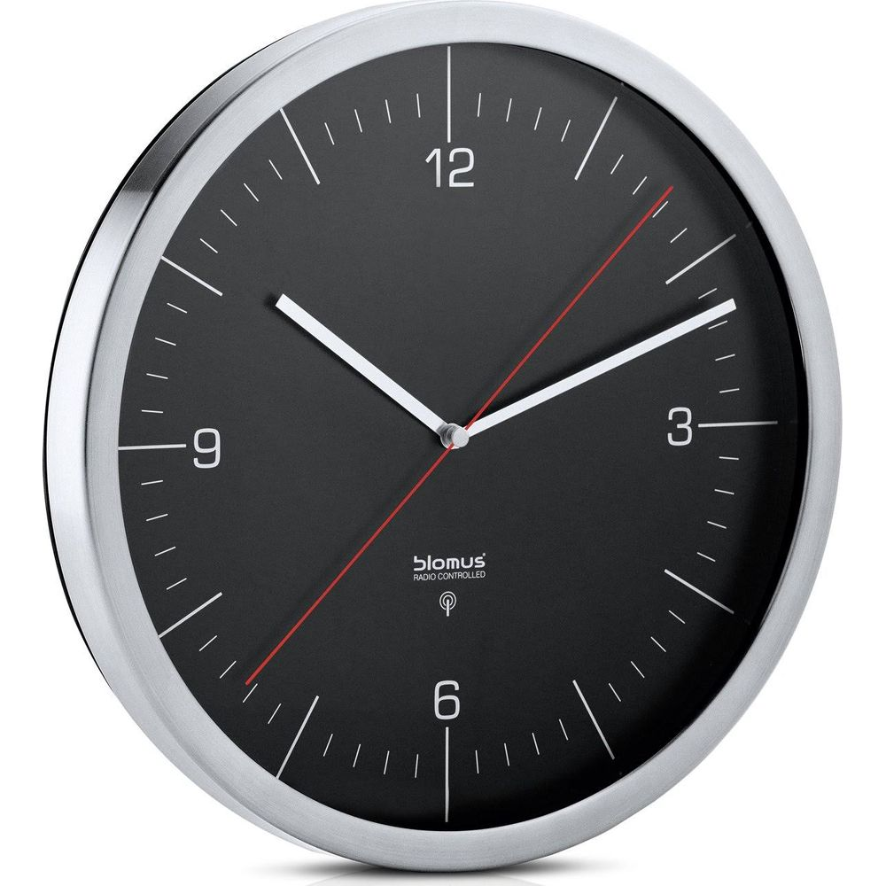 Une horloge murale noire avec un bord argenté et une trotteuse rouge.
