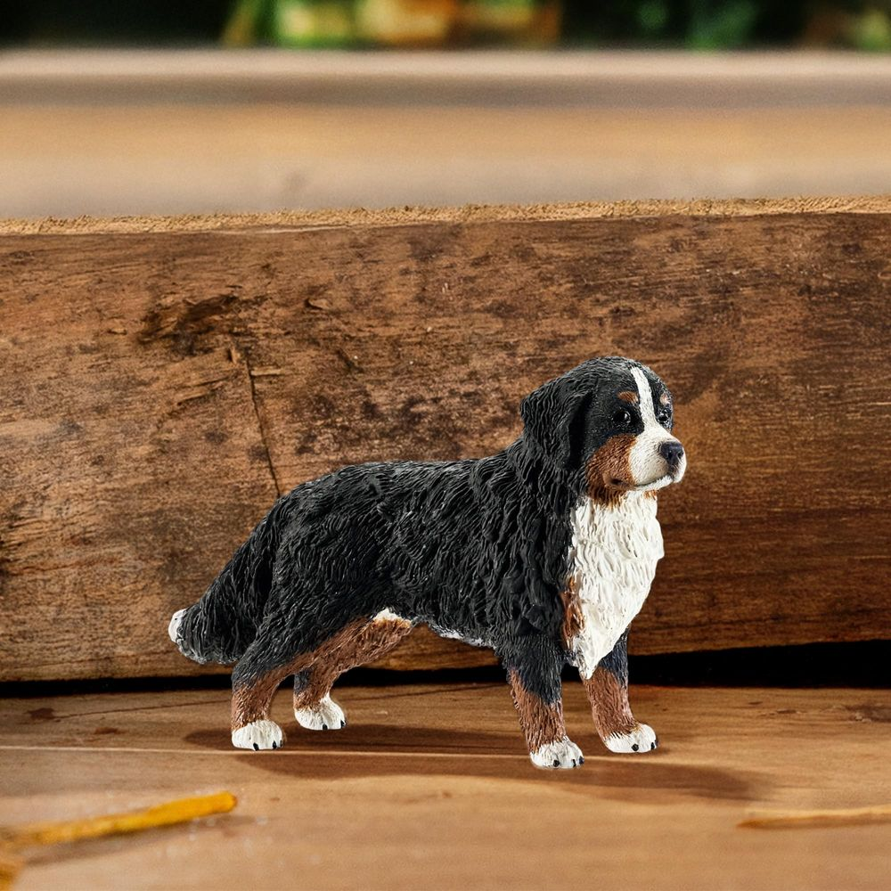 Figurka psa rasy Berneński Pies Pasterski na drewnianym tle.