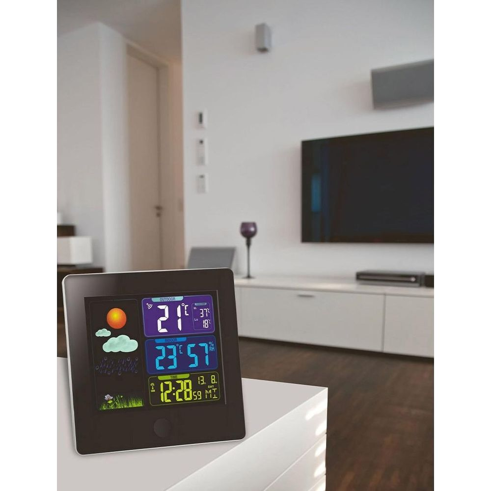 Cyfrowa stacja pogodowa: temp. zewn. 21°C, wewn. 23°C, wilgotność 57%, godz. 12:28.