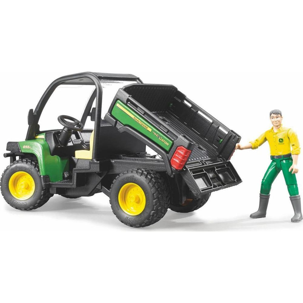 Zabawkowy John Deere Gator z podniesioną skrzynią i stojącą obok figurką rolnika.