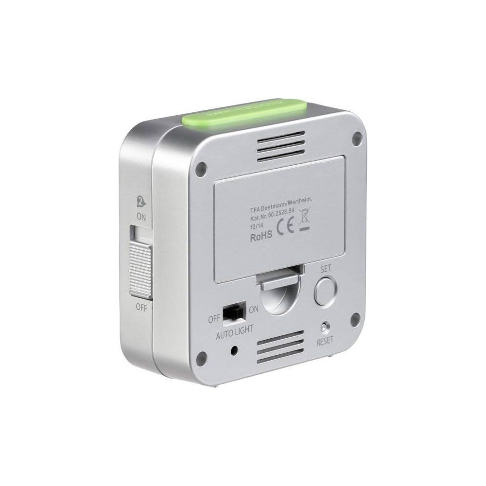 Srebrny budzik z zielonym przyciskiem i przełącznikami z boku.