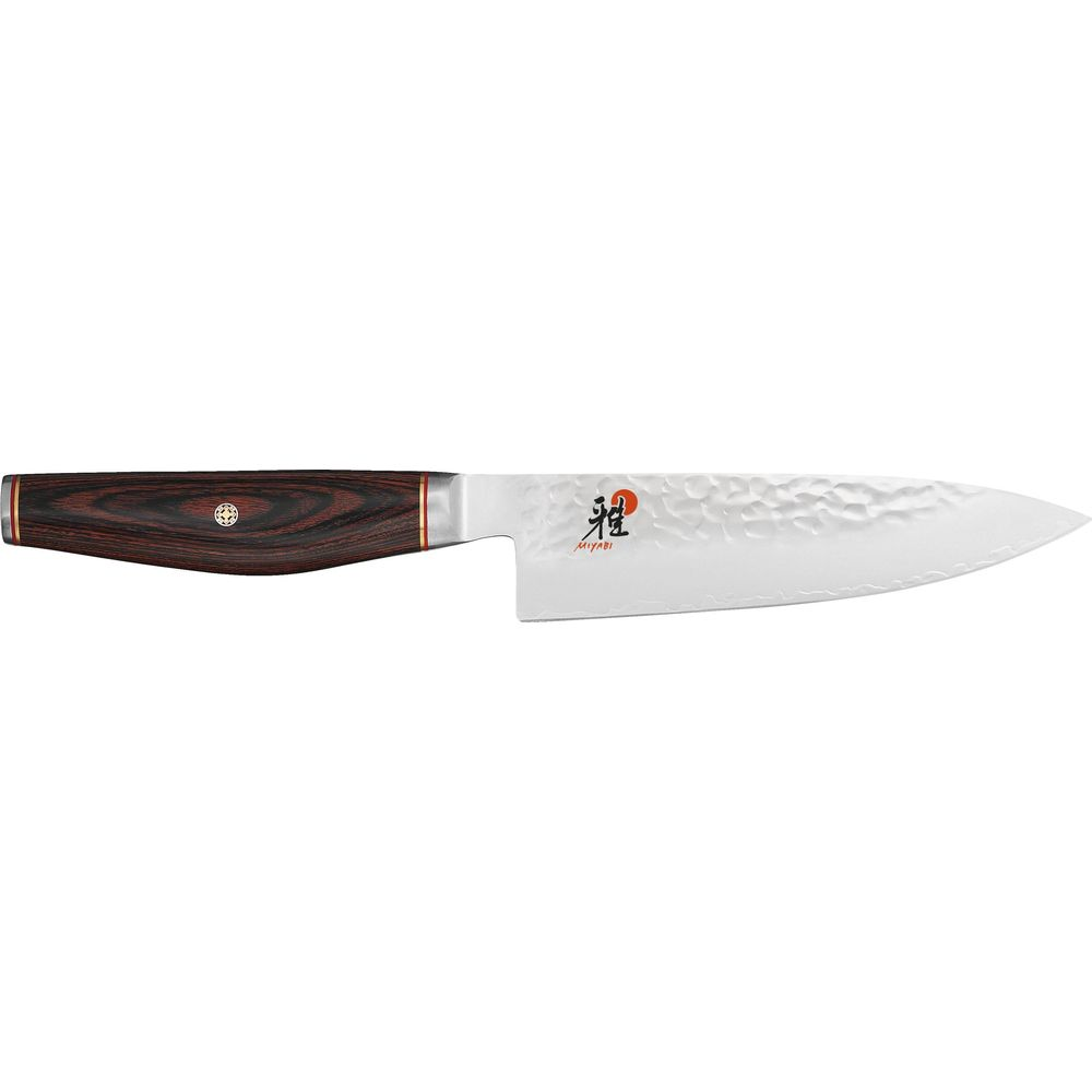 Un coltello da cucina affilato con manico in legno scuro e lama in metallo martellato.