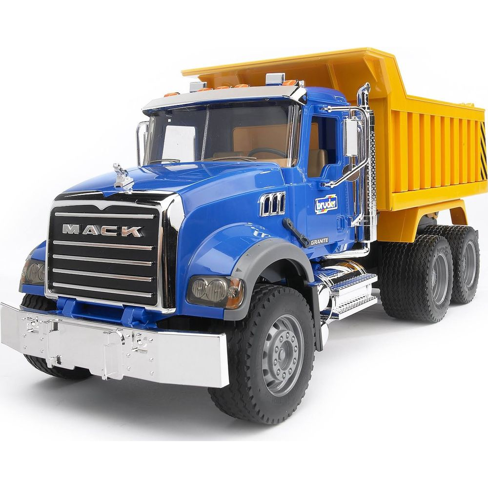 Niebieska zabawka wywrotka z żółtą skrzynią stoi na białym tle.