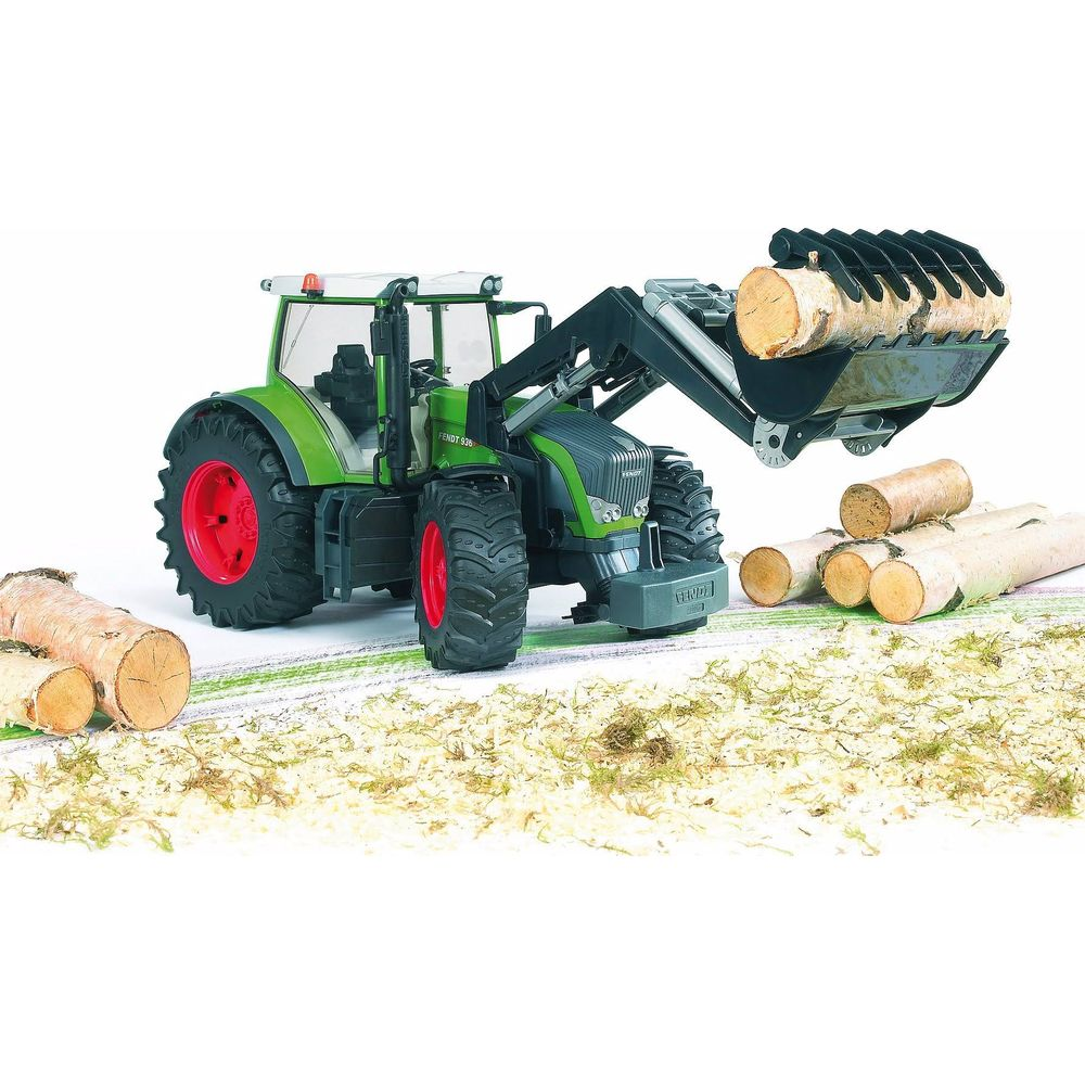 Zielny traktor-zabawka z ładowaczem czołowym podnoszący kłody.