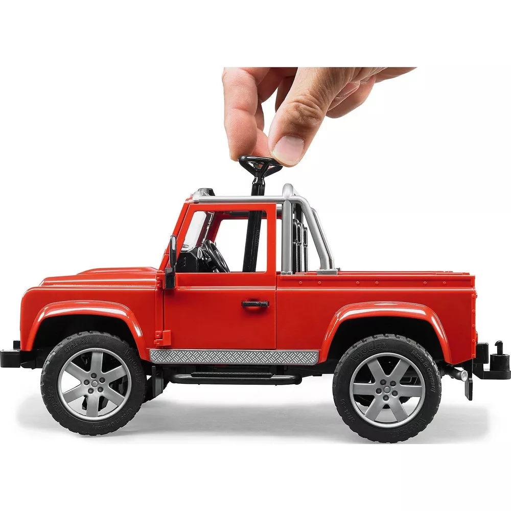 Pickup giocattolo rosso con ruote argentate. Mano gira volante in alto.