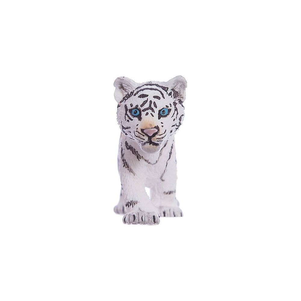 Un tigre blanc aux yeux bleus et rayures noires se tient de face.