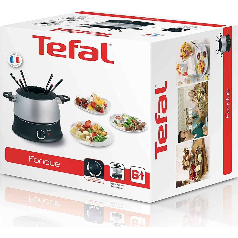 Zestaw do fondue Tefal z srebrnym garnkiem, czarną podstawą i talerzami z owocami, serem i mięsem.