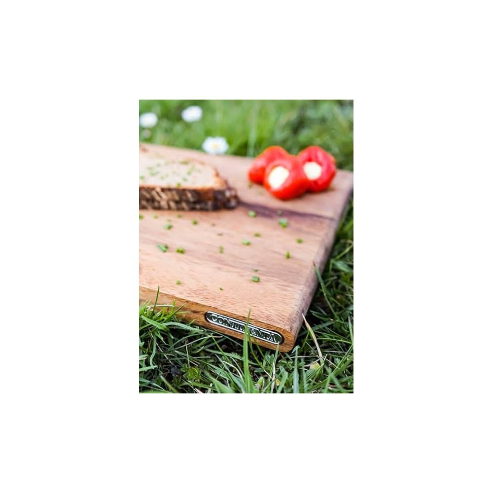 Ein Holzbrett mit Brot und gefüllten Paprika auf Gras.