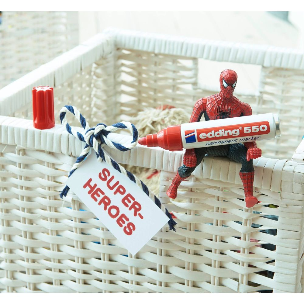 Spiderman sitzt auf einem weißen Korb und hält einen roten Edding-Marker.