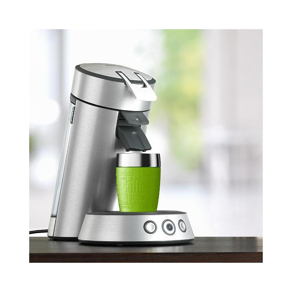 Silberne Kaffeemaschine mit grünem Becher, auf dunklem Tisch.