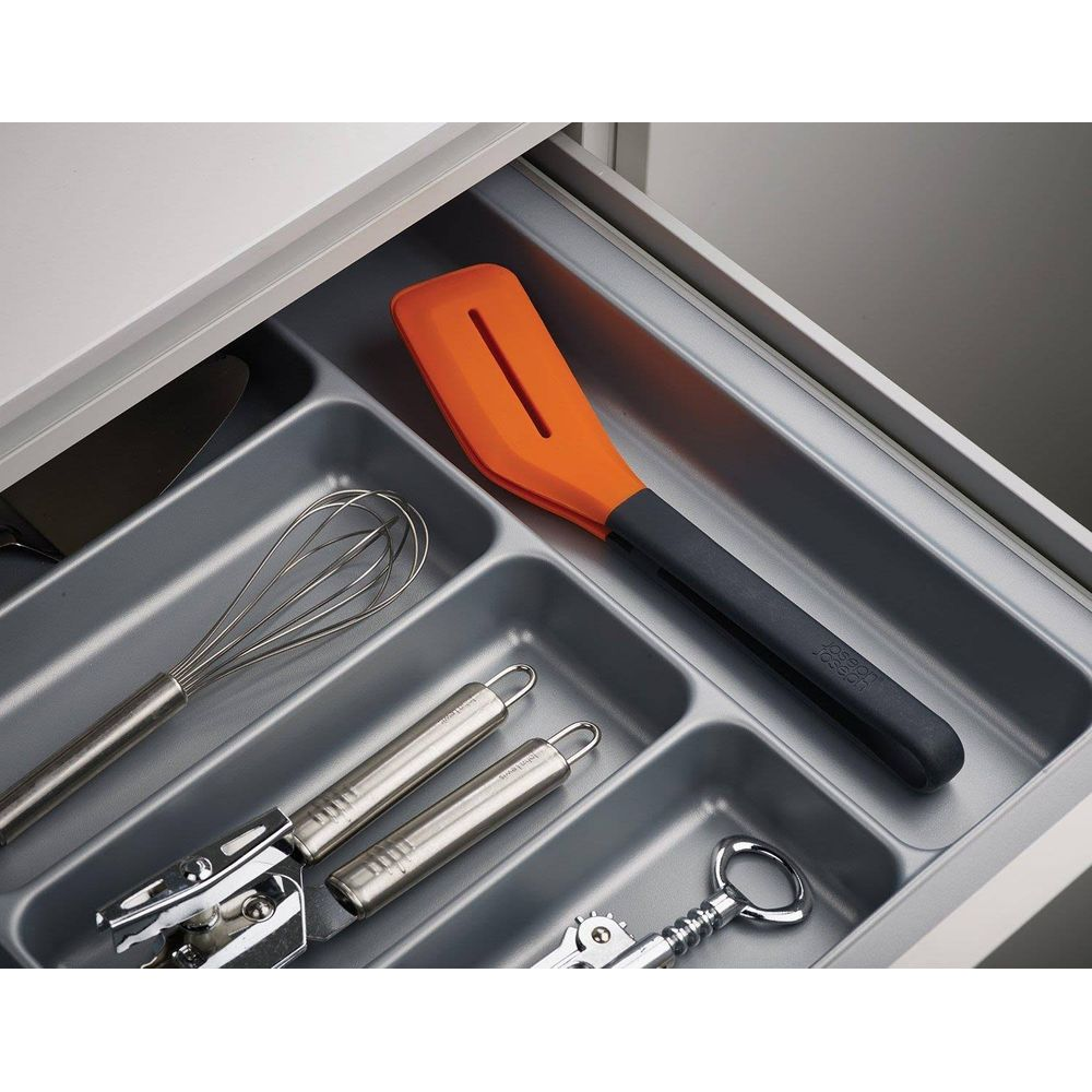 Utensilios de cocina en un cajón: batidor, abrelatas, sacacorchos, espátula.