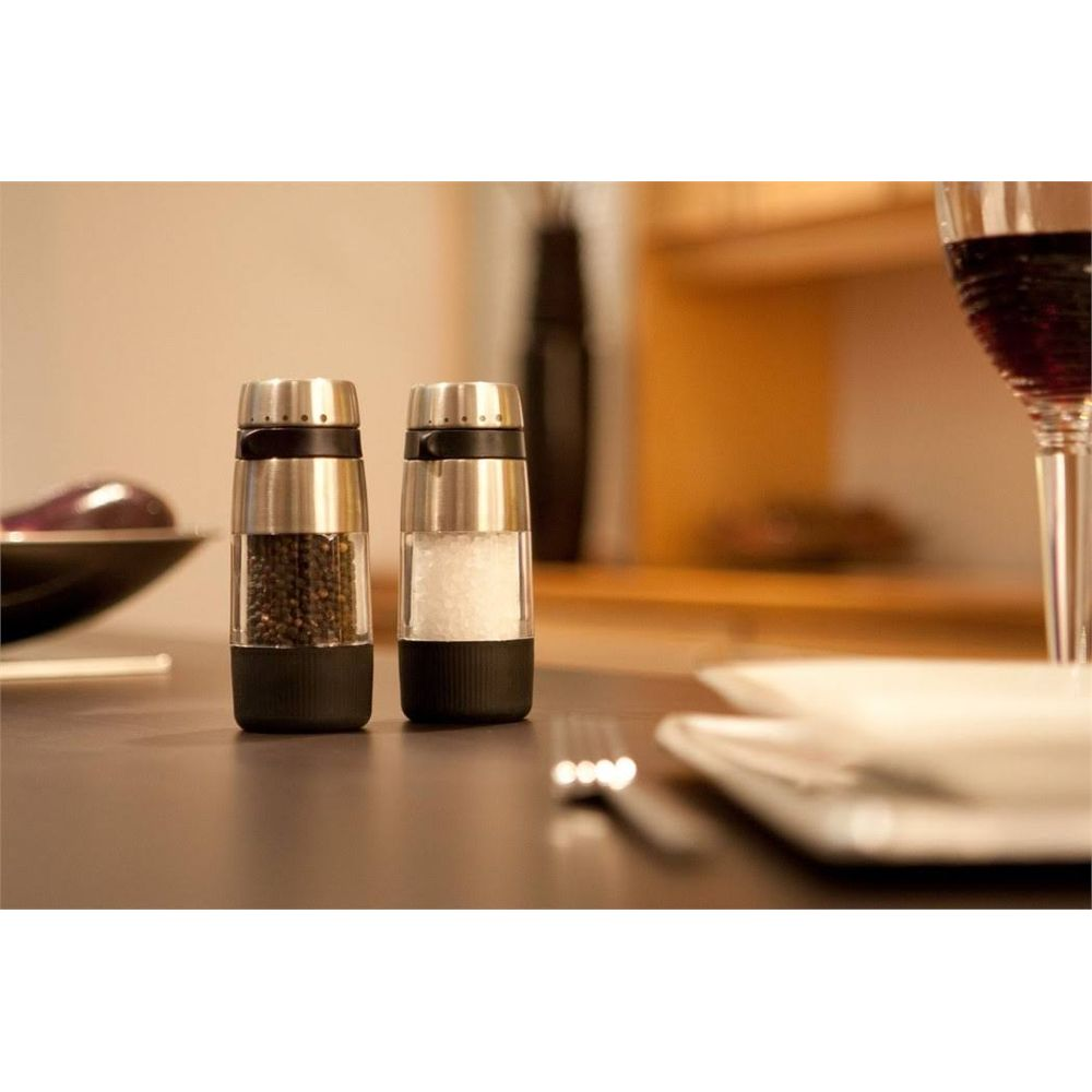 Dwa młynki, jeden z pieprzem, drugi z solą, na stole.